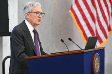 Federal Reserve Board Chairman Jerome Powell speaking at a podium with the striped portion of the American flag visible to his right