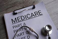 Close up image of stethoscope and paper clipboard with text MEDICARE and part list. Medical and healthcare concept