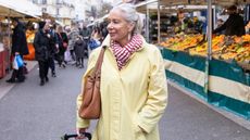 An older woman in France shops at an outdoor market.