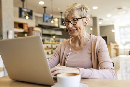 Female working on her laptop wearing headphones