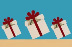 three holiday presents with red bows and money inside